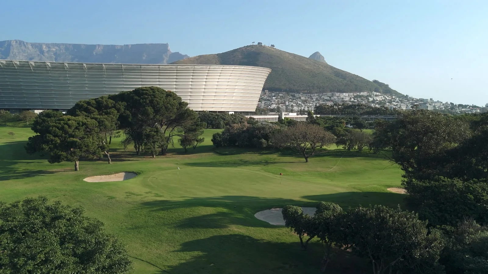 A green in front of the stadium, Table Mountain and Signal Hill