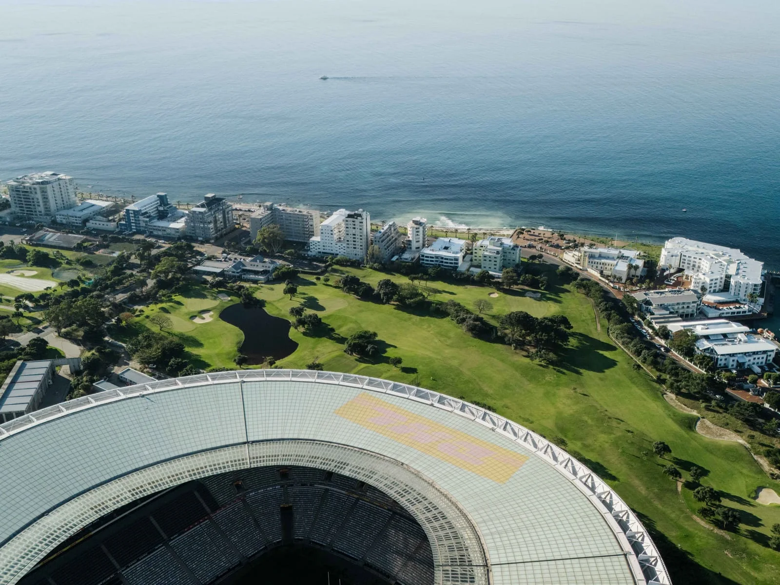 The stadium roof and the course beside the sea, from above